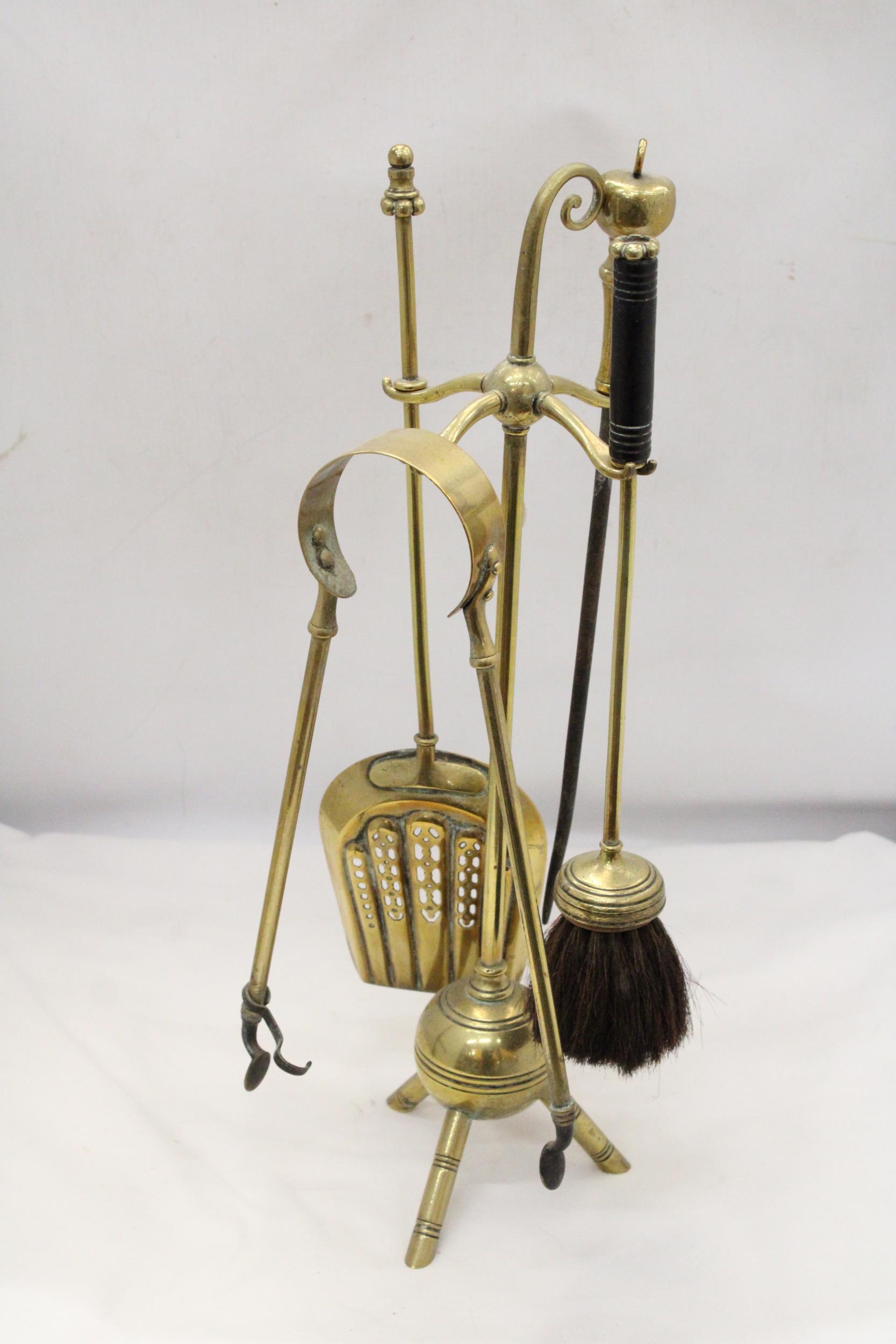 A 1930'S TRIPOD BRASS COMPANION SET