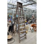 A VINTAGE TEN RUNG WOODEN STEP LADDER AND A FURTHER FIVE RUNG WOODEN STEP LADDER