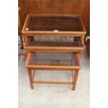 A RETRO TEAK NEST OF THREE TABLES WITH INSET GLASS TOPS