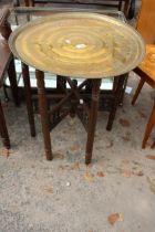 AN INDIAN BRASS 28" DIAMETER TABLE ON FOLDING TURNED BASE