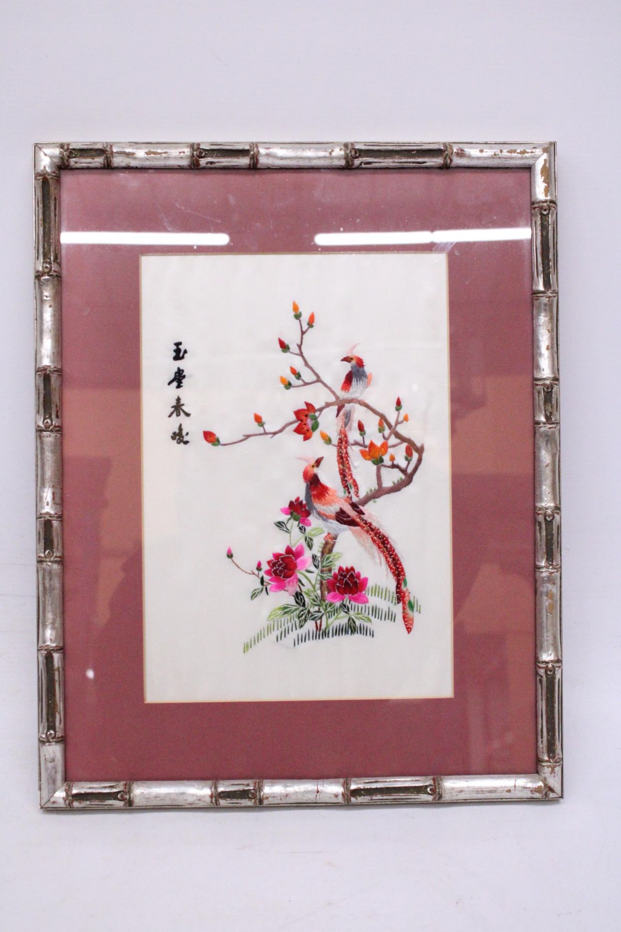 AN ORIENTAL SILK HAND EMBROIDERED ART PIECE IN A BAMBOO FRAME