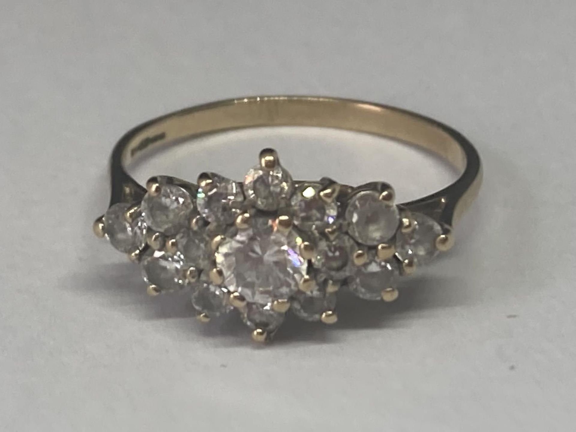 A 9 CARAT GOLD RING WITH CUBIC ZIRCONIAS IN A CLUSTER DESIGN SIZE O