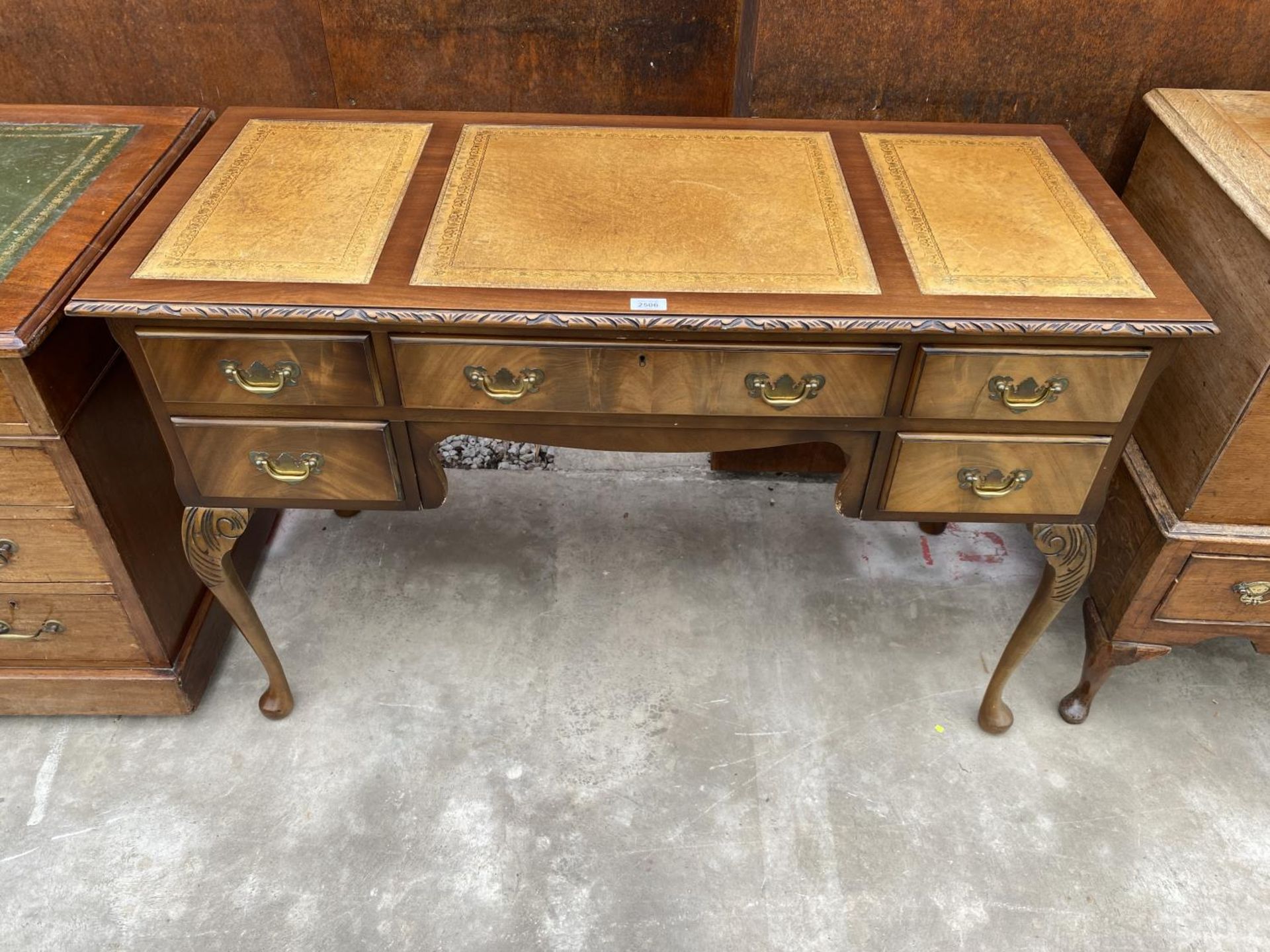 A MID 20TH CENTURY MAHOGANY KNEE HOLE DESK ENCLOSING SHORT AND ONE LONG DRAWER ON CABRIOLE LEGS WITH