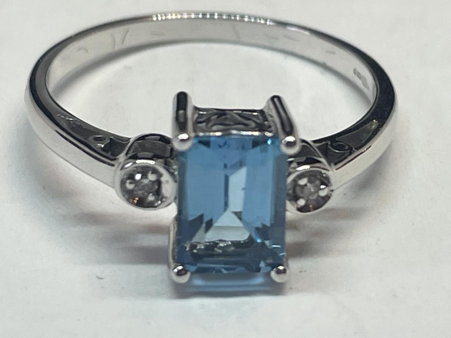 A 9 CARAT WHITE GOLD RING WITH A LARGE RECTANGULAR BLUE TOPAZ AND A DIAMOND EACH SIDE (EMERALD - Image 3 of 6