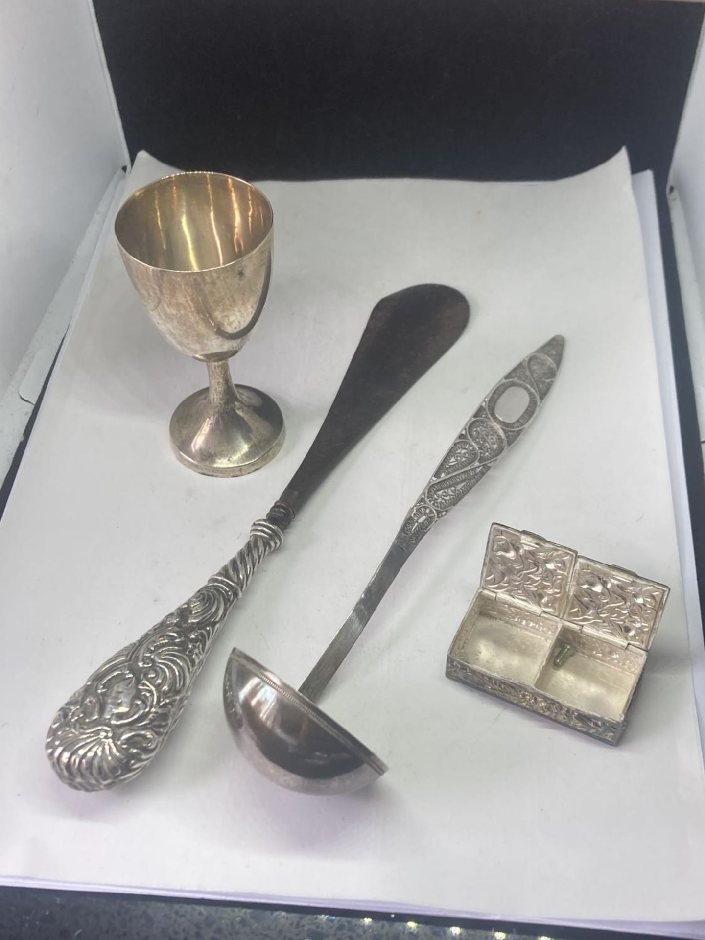 FOUR POSSIBLY SILVER ITEMS TO INCLUDE A GOBLET, LADLE, PILL BOX AND SHOE HORN