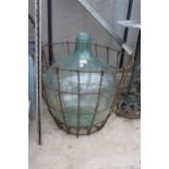A LARGE VINTAGE GLASS CARBOY WITH WIRE CRATE