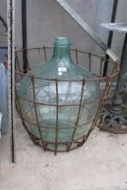 A LARGE VINTAGE GLASS CARBOY WITH WIRE CRATE