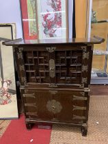 A KOREAN WOOD AND BRASS APOTHECARY CABINET, REVEALING 14 DRAWERS, STACKED ON A HINGED DOOR