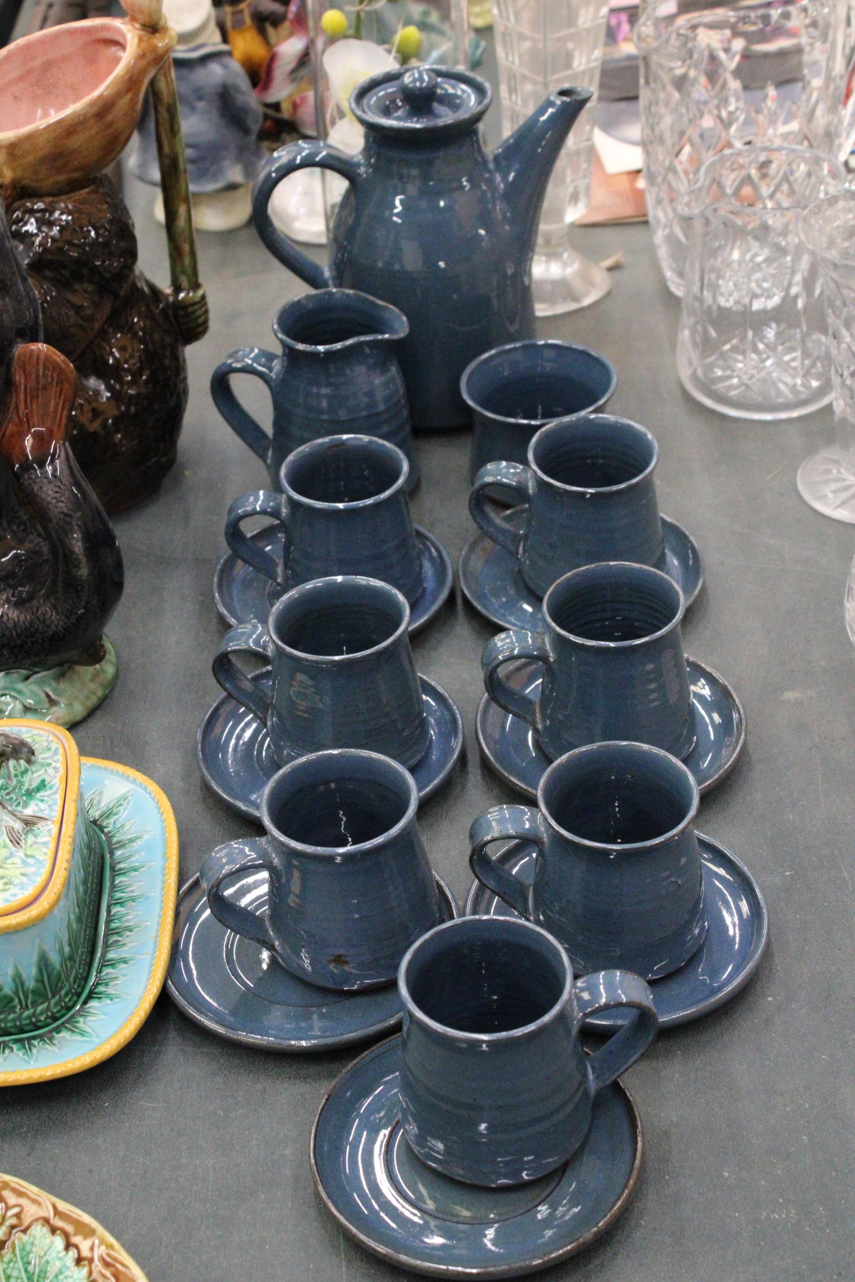 A VINTAGE STUDIO POTTERY TEA SET TO INCLUDE A JUG, SUGAR BOWL, TEAPOT AND EIGHT CUPS AND SAUCERS