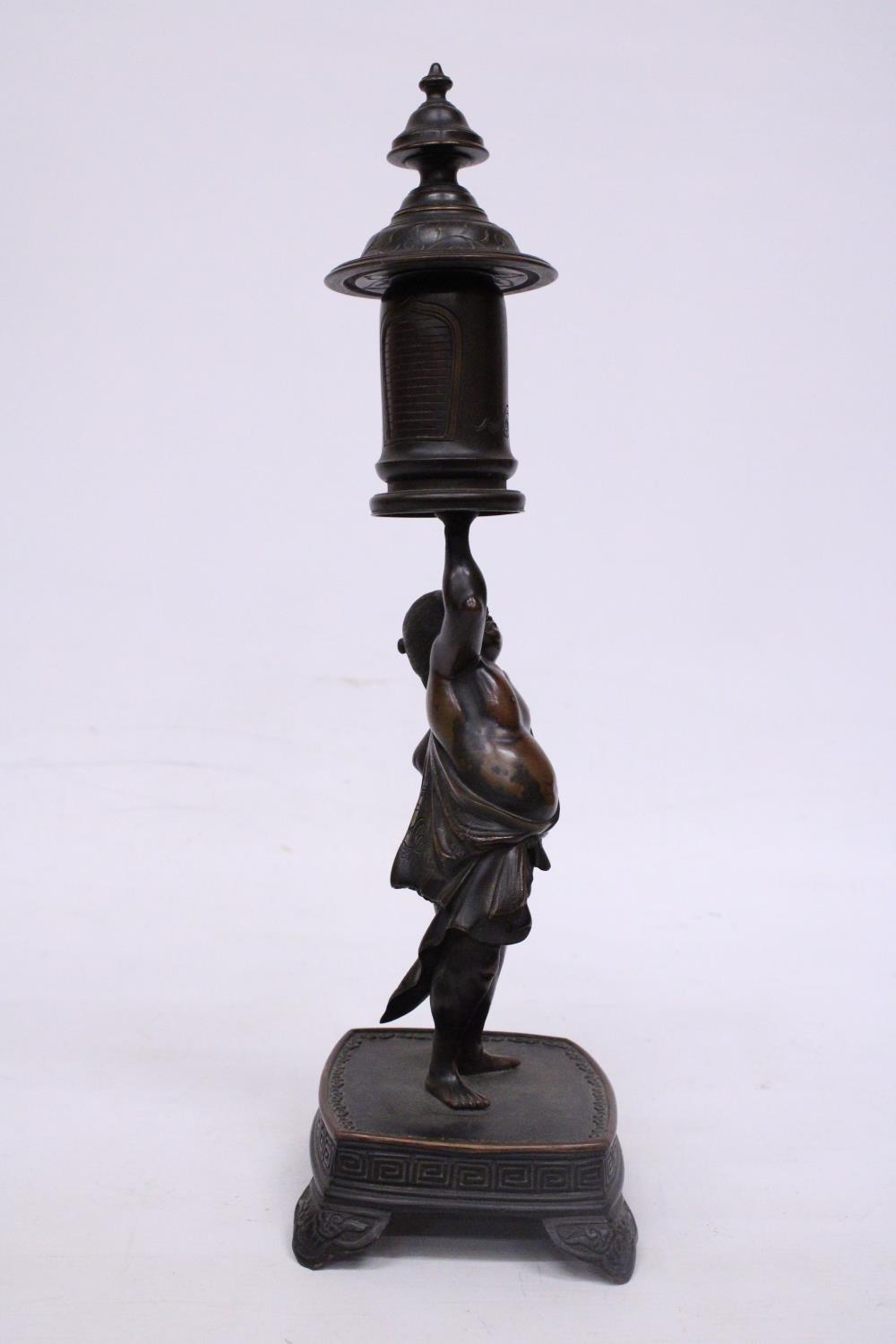 A BRONZE MEIJI PERIOD STATUE OF A FIGURE HOLDING A VASE WITH COVER - Image 4 of 7