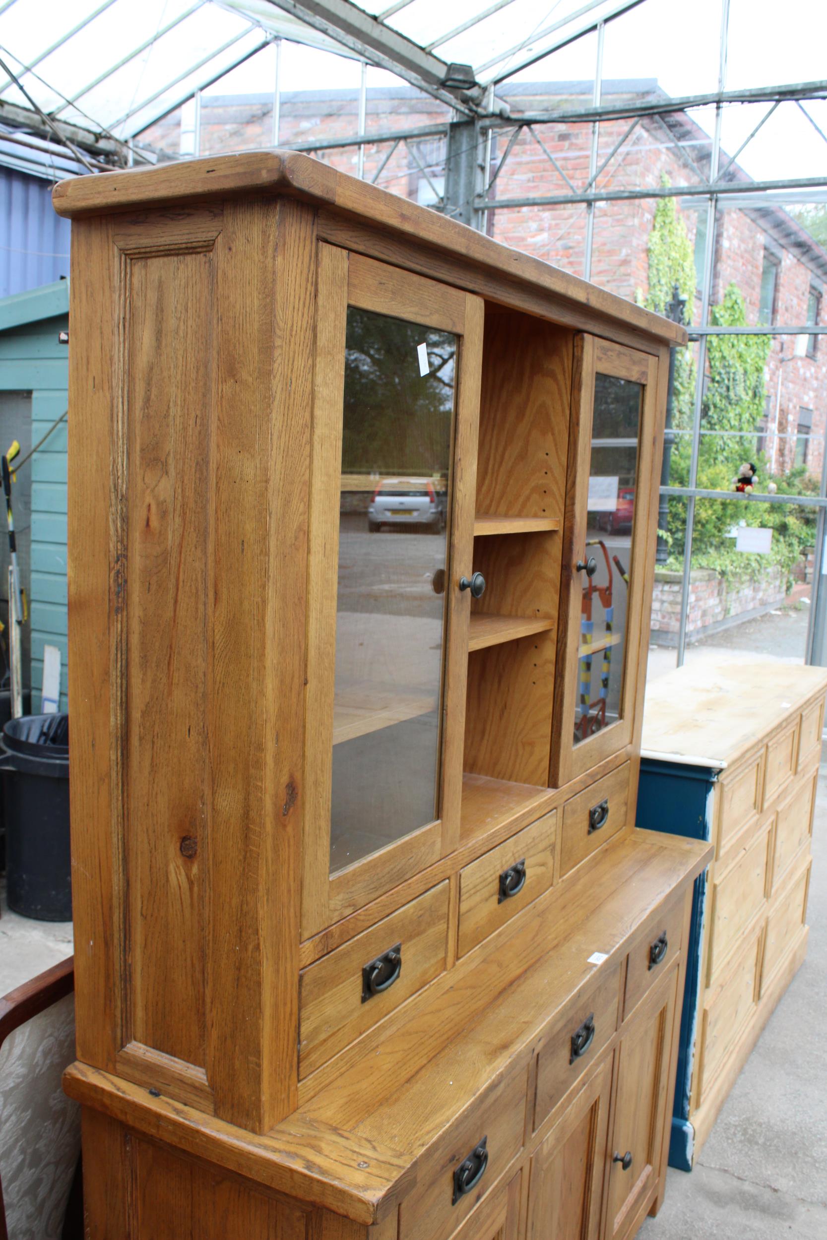 A OAK TWO DOOR BOOKCASE ON BASE, ENCLOSING SIX DRAWERS AND THREE CUPBOARDS, 55" WIDE - Image 2 of 6