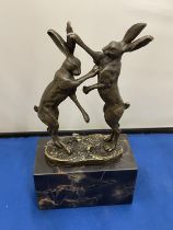 A PAIR OF BRONZE BOXING HARES ON A MARBLE BASE