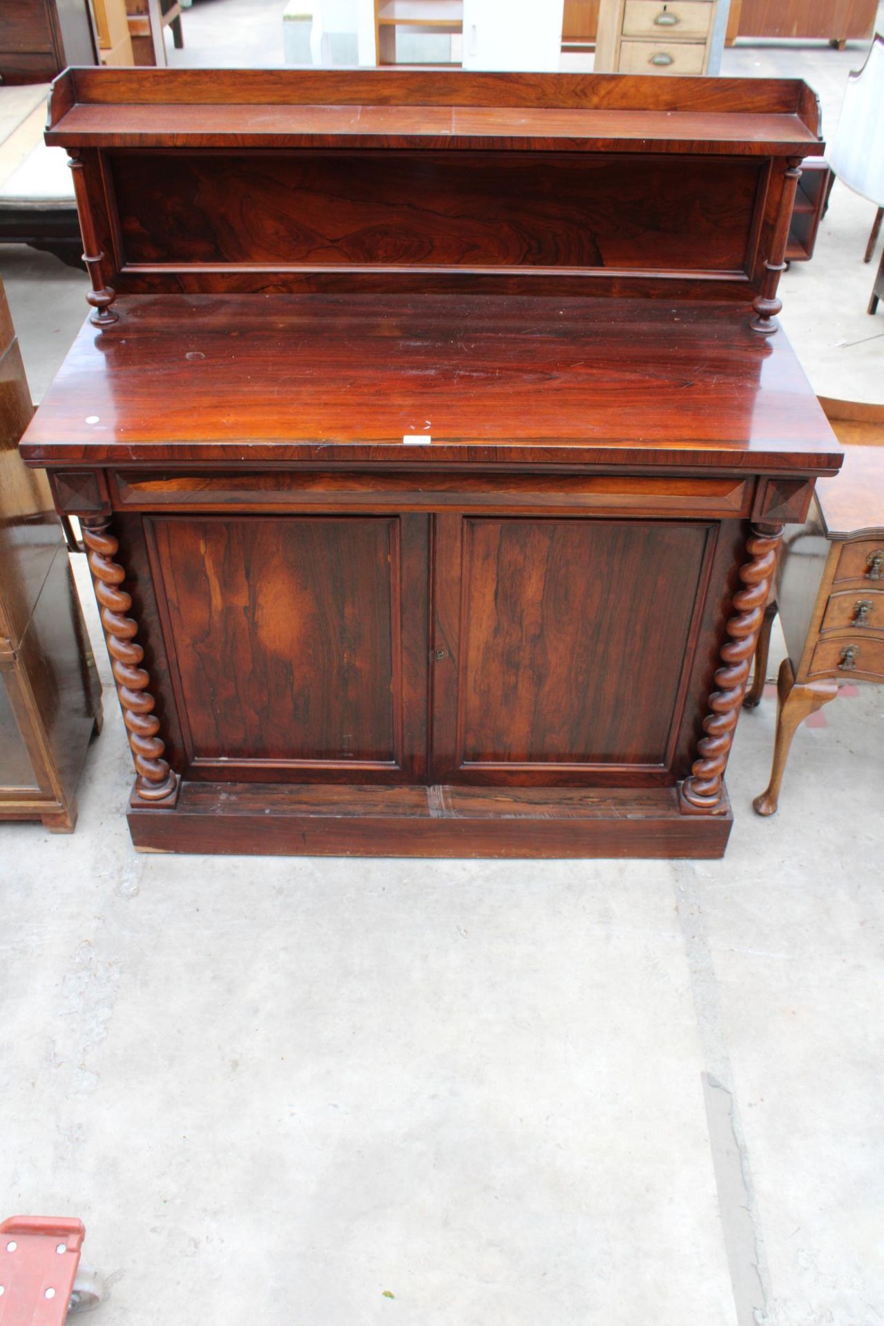 A VICTORIAN ROSEWOOD CHIFFONIER ENCLOSING TWO CUPBOARDS WITH BARLEY-TWIST COLUMNS, FRIEZE DRAWER AND