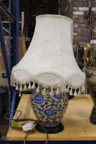 A BLUE AND CREAM ORIENTAL STYLE LAMP WITH SHADE