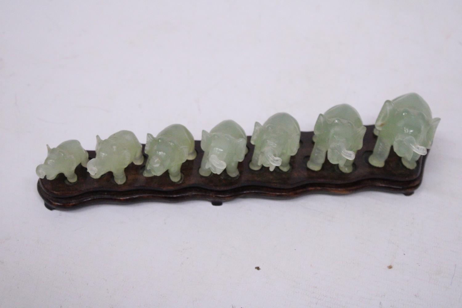 SEVEN GRADUATING JADE ELEPHANTS ON A WOODEN PLINTH (1 A/F) - Image 4 of 5