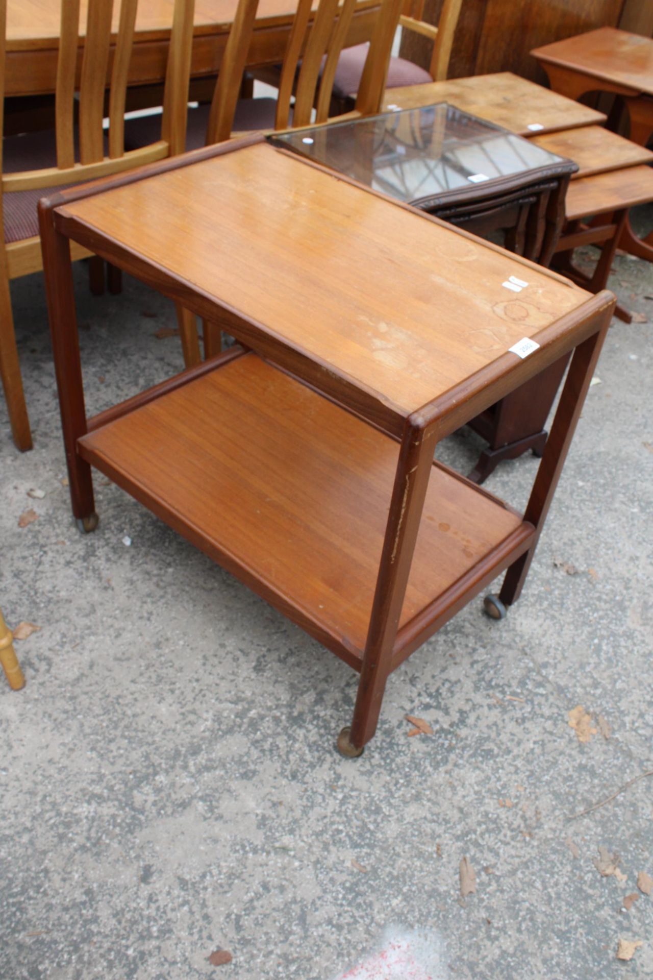 A RETRO TEAK TWO TIER TROLLEY ON CASTERS