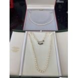 TWO BOXED STRINGS OF PEARLS ONE WITH A 9 CARAT GOLD CLASP AND ONE WITH A SILVER CLASP