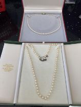 TWO BOXED STRINGS OF PEARLS ONE WITH A 9 CARAT GOLD CLASP AND ONE WITH A SILVER CLASP