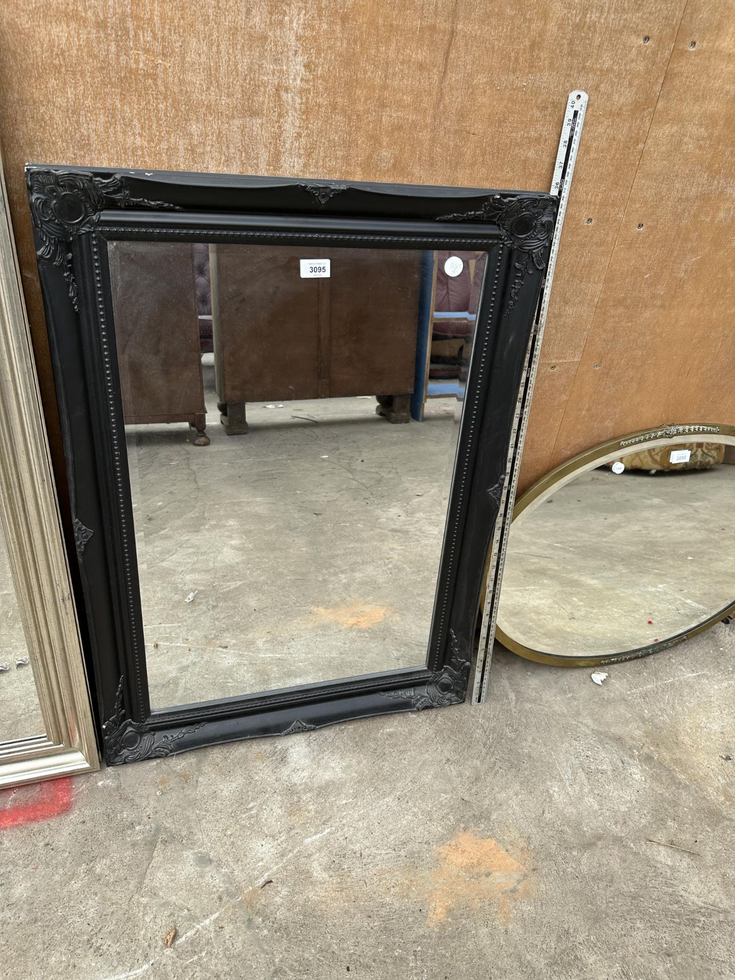 A RECTANGULAR BLACK FRAMED MIRROR