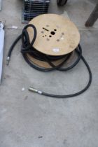 A WOODEN CABLE REEL WITH AN AIRLINE HOSE