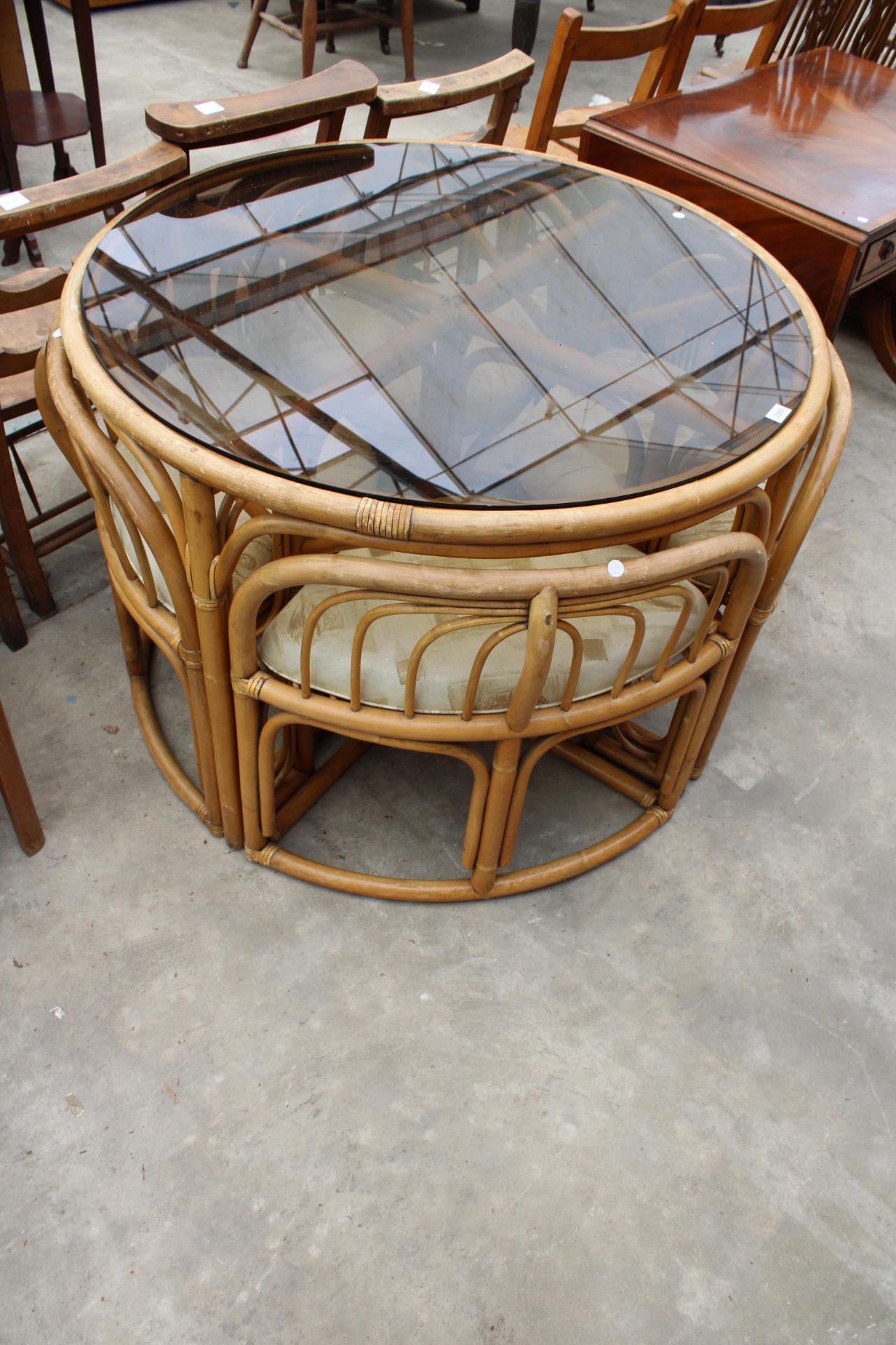 A MODERN 41" DIAMETER BAMBOO AND WICKER DINING TABLE WITH SMOKED GLASS TOP AND FOUR DINING CHAIRS