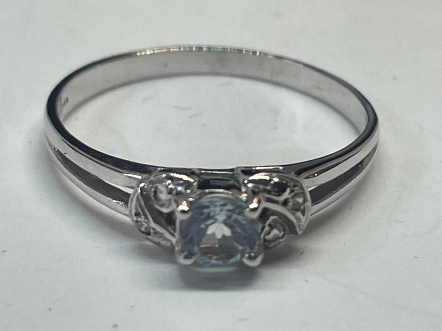 A 9 CARAT WHITE GOLD RING WITH CENTRE BLUE TOPAZ SHOULDERED BY DIAMONDS SIZE N IN A PRESENTATION BOX - Image 3 of 5