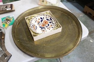A MIDDLE EASTERN BRASS TRAY - 57 CM DIAMETER TOGETHER WITH A BOXED IMARI STYLE PLATE