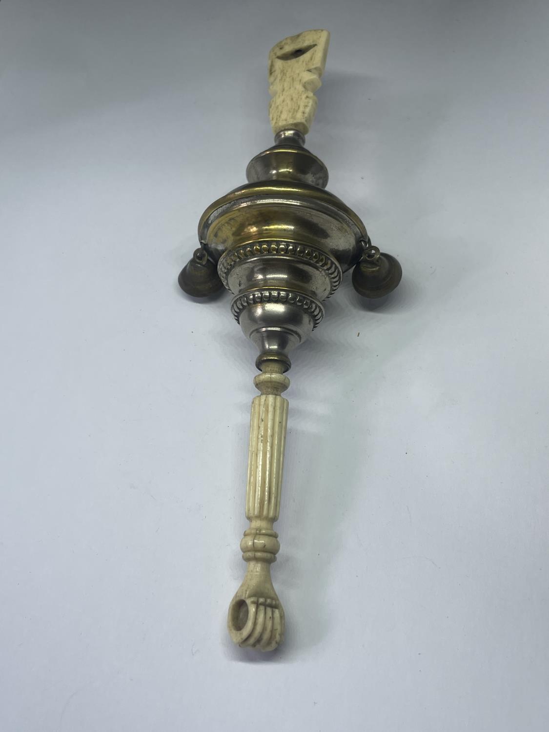 A VINTAGE BONE AND WHITE METAL WHISTLE AND RATTLE