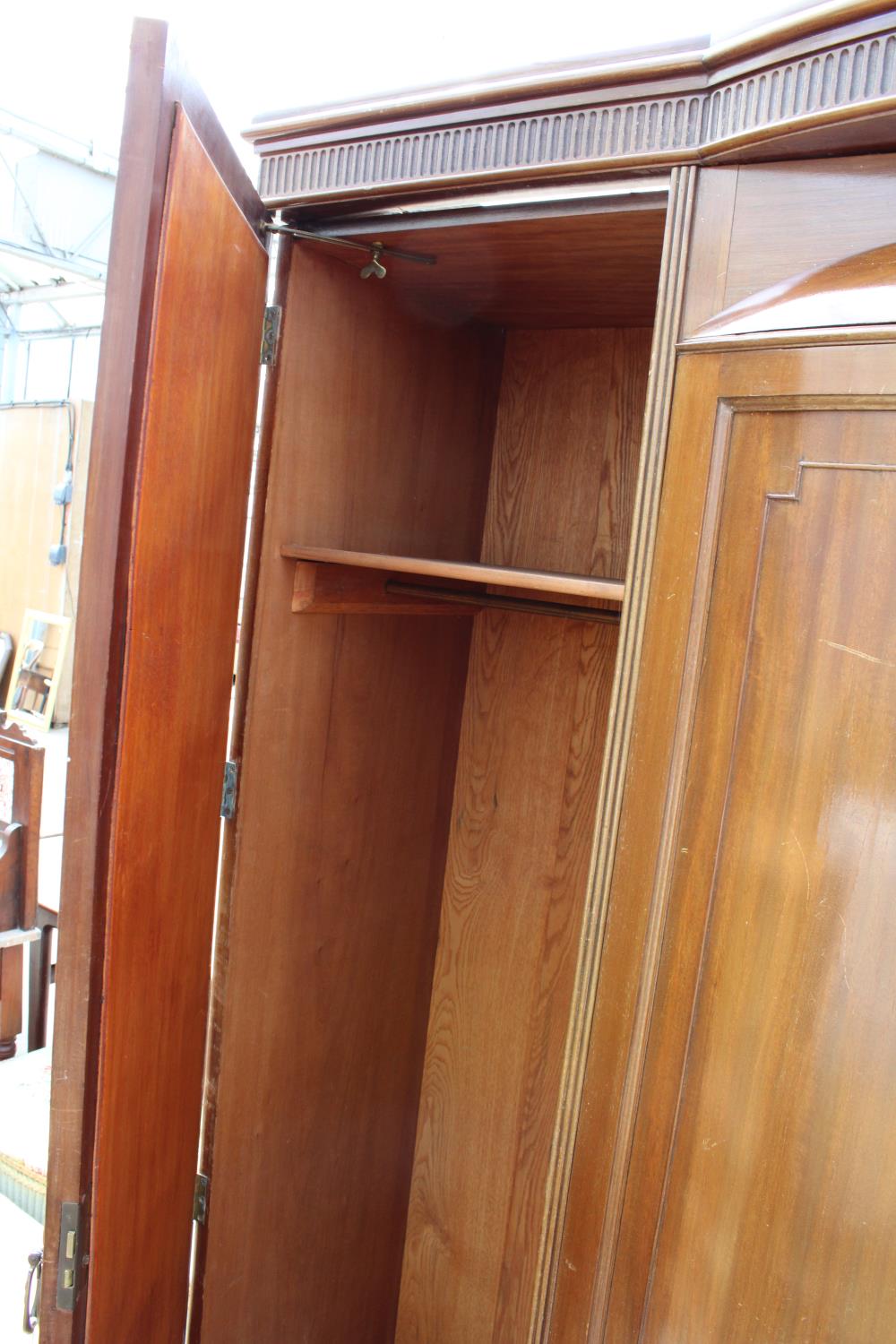 AN EDWARDIAN MAHOGANY PARTIALLY BOW FRONTED MIRROR-DOOR WARDROBE ON BRACKET FEET, 61" WIDE - Image 4 of 5