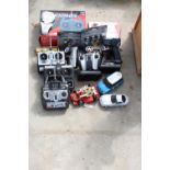 AN ASSORTMENT OF REMOTE CONTROL CARS AND AN ASSORTMENT OF R/C CONTROLLERS