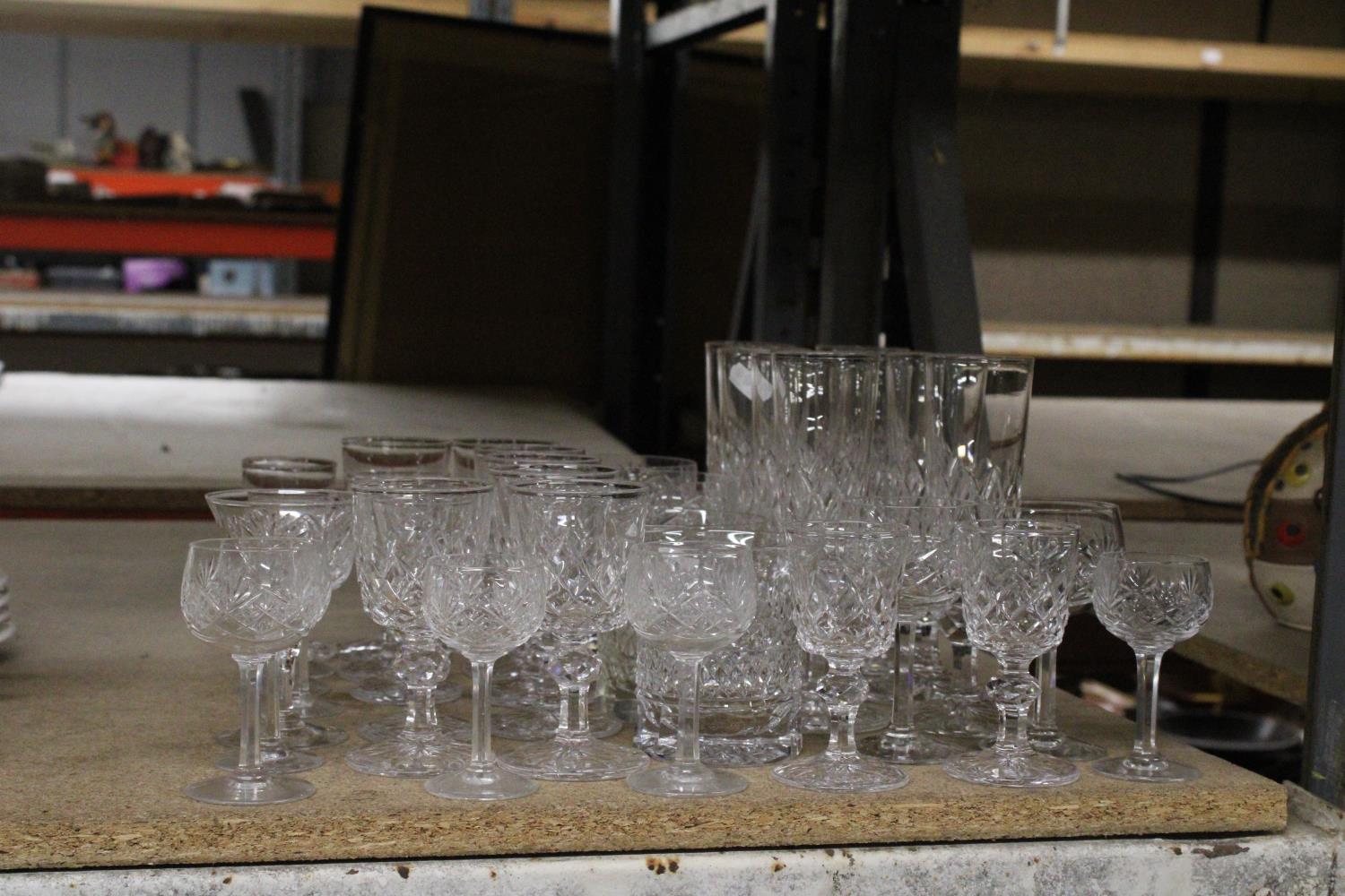 A QUANTITY OF CUT GLASS GLASSES TO INCLUDE CHAMPAGNE FLUTES, WHISKY, WINE, SHERRY, PORT, ETC