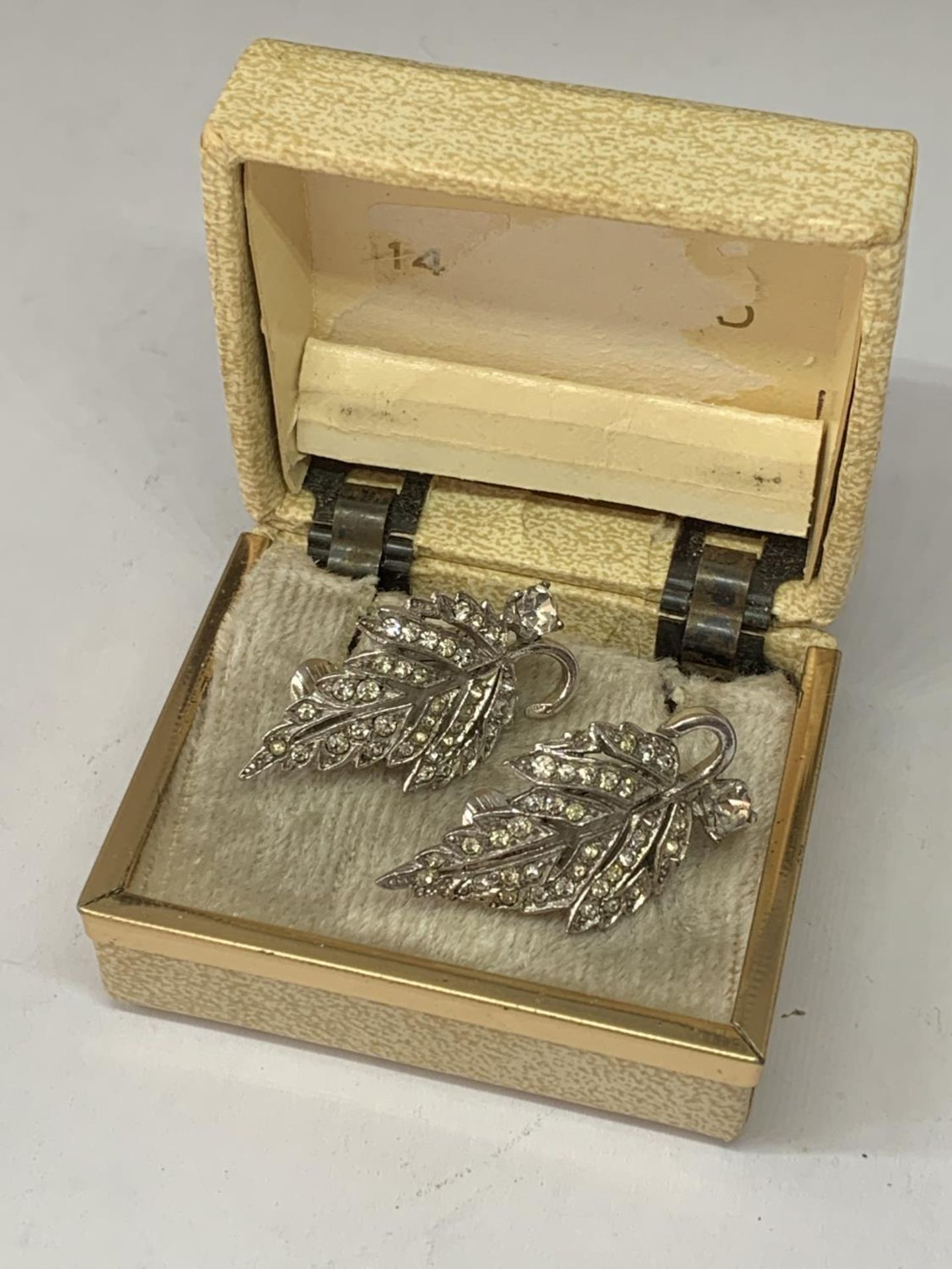A PAIR OF 1940'S METAL RHODIUM AND CLEAR STONE EARRINGS IN A LEAF DESIGN WITH PRESENTATION BOX