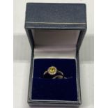 A 9 CARAT GOLD RING WITH CENTRECITRINE SURROUNDED BY CLEAR STONES SIZE K/L IN A PRESENTATION BOX