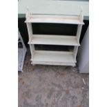 A WHITE PAINTED THREE TIER WALL SHELF ENCLOSING THREE DRAWERS, 26" WIDE