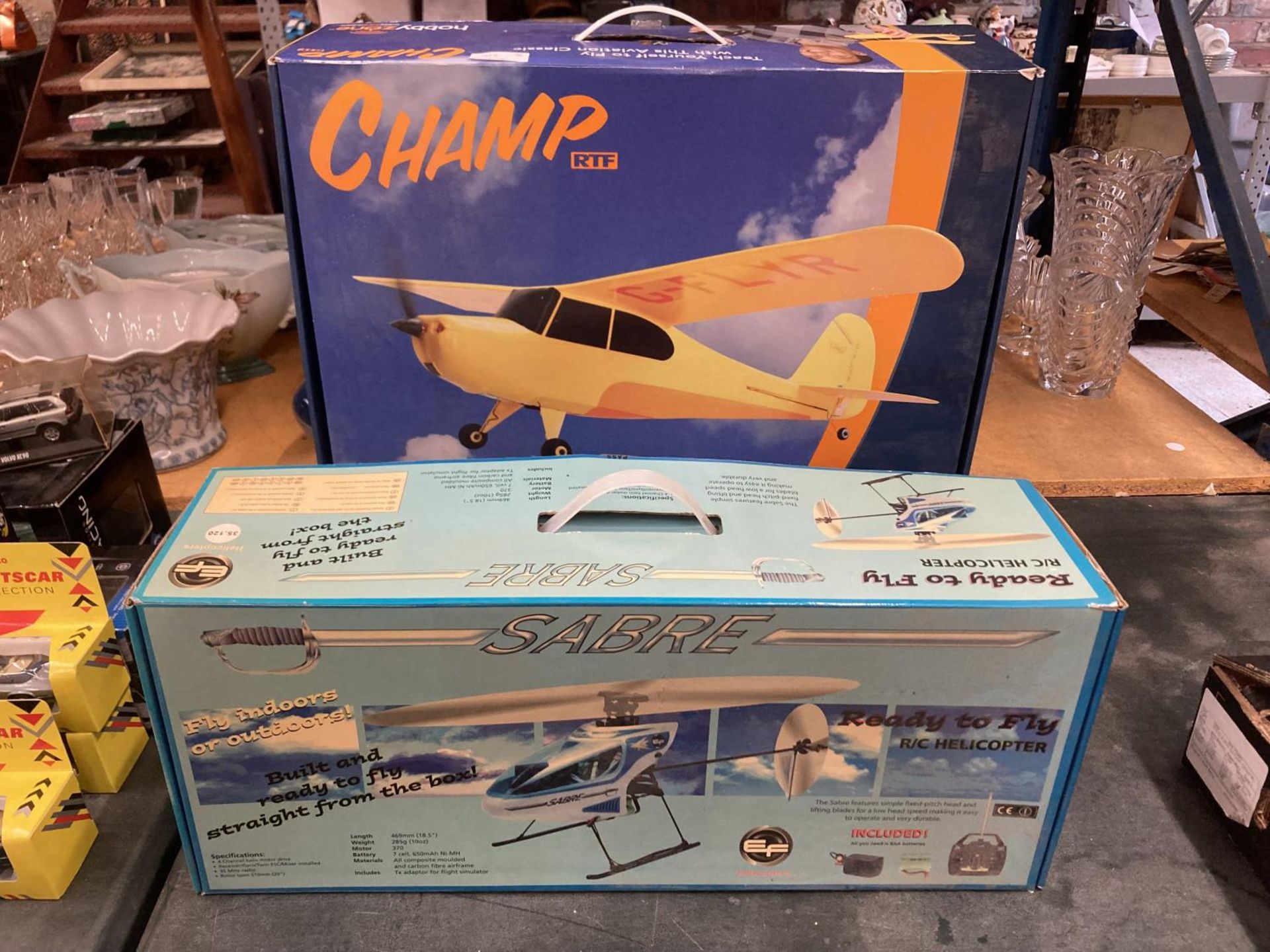 A BOXED SABRE READY TO FLY R/C HELICOPTER AND A HOBBYZONE R/C AREOPLANE, BOTH CONTROLLERS PRESENT