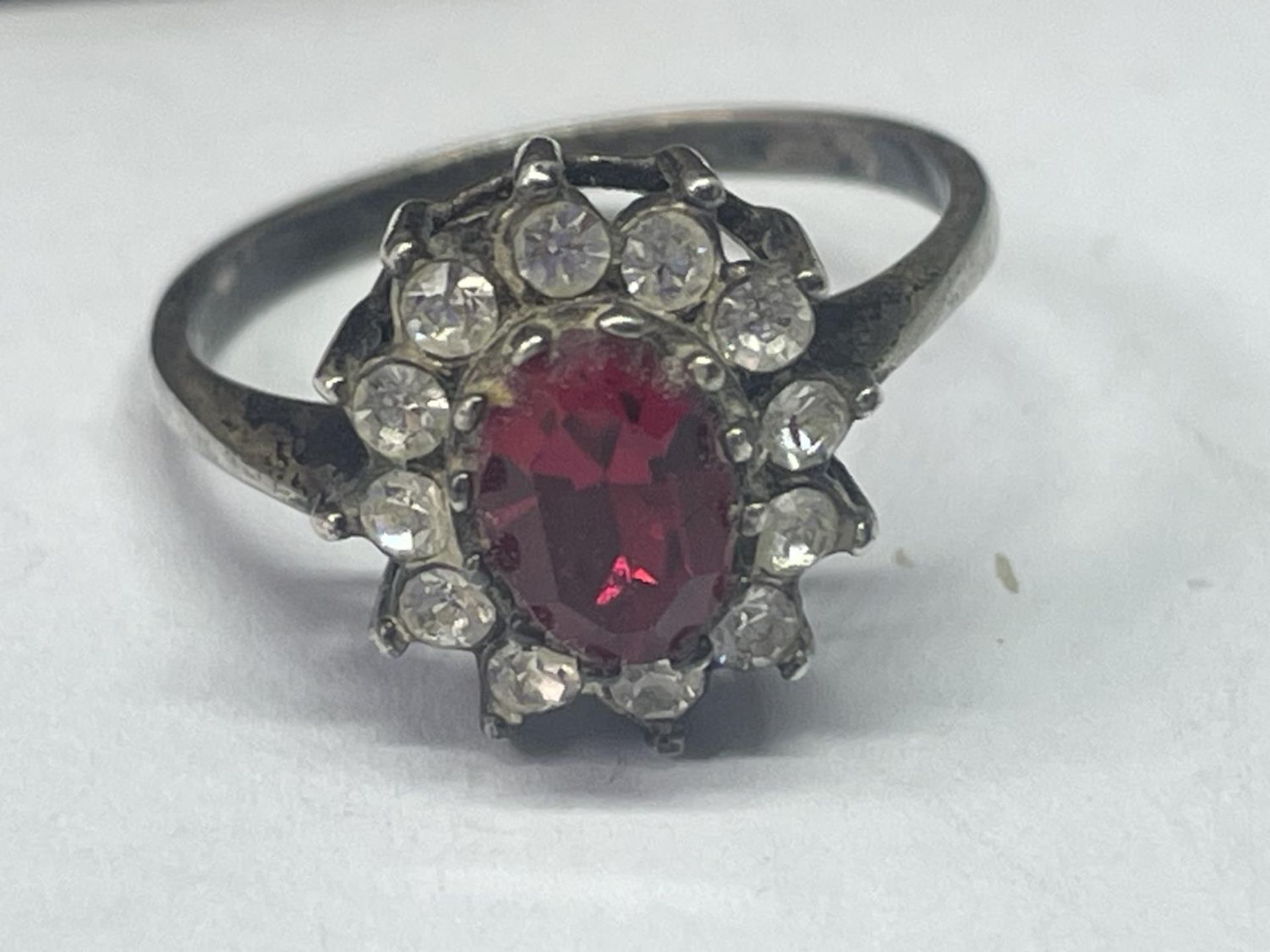A SILVER RING WITH CENTRE RED STONE SURROUNDED BY CLER STONES IN A PRESENTATION BOX - Image 2 of 3