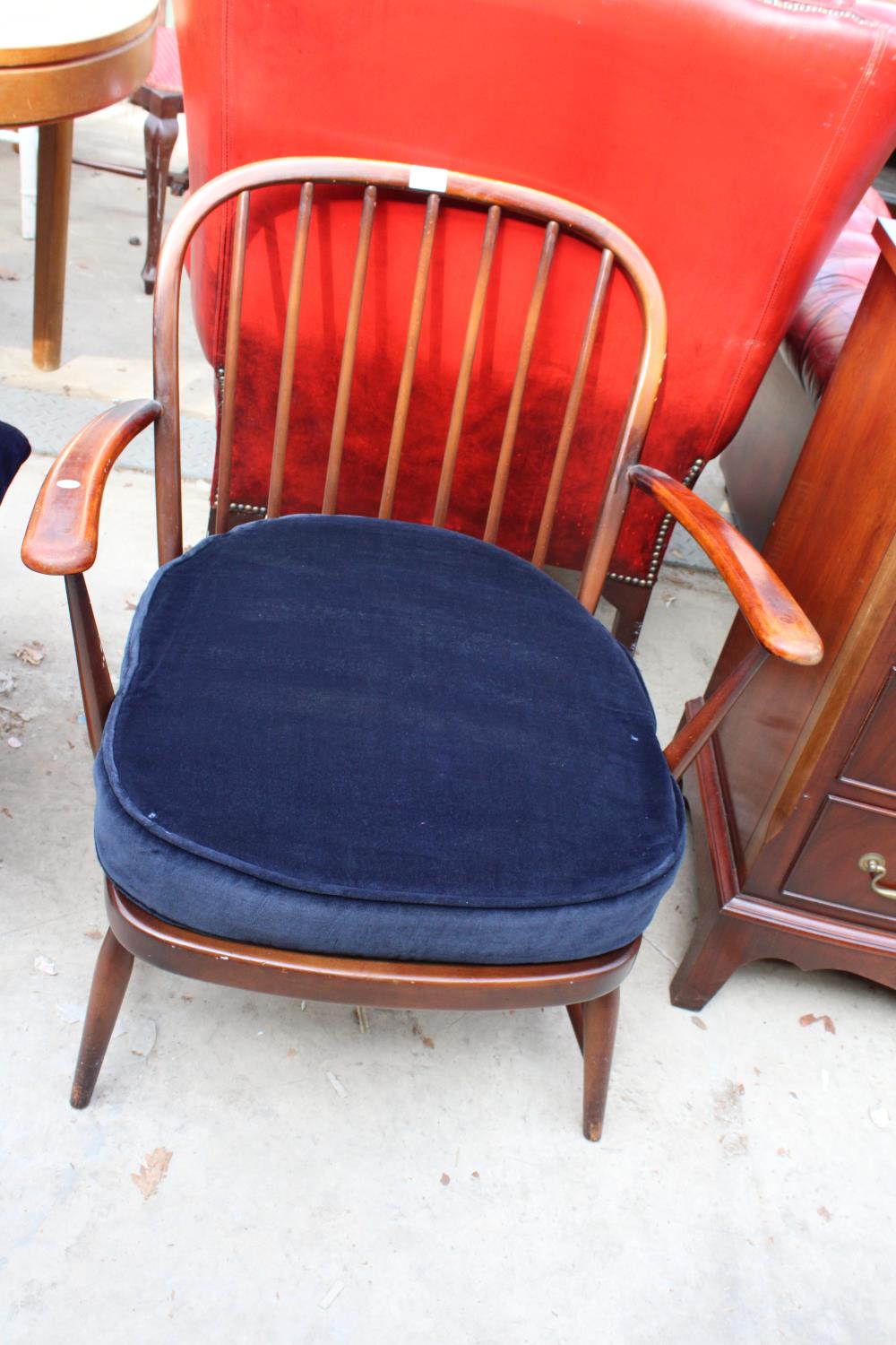AN ERCOL STYLE FIRESIDE CHAIR WITH SPINDLE BACK