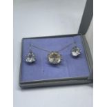 A SILVER CLEAR STONE NECKLACE AND EARRINGS IN A PRESENTATION BOX