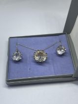 A SILVER CLEAR STONE NECKLACE AND EARRINGS IN A PRESENTATION BOX