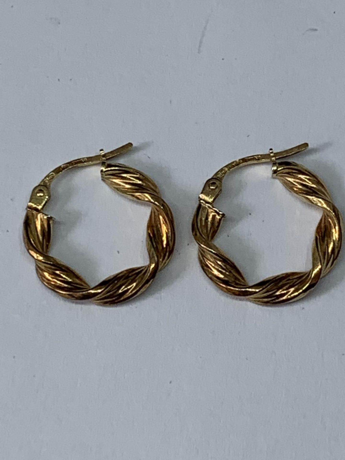 A PAIR OF 9 CARAT GOLD TWISTED HOOP EARRINGS GROSS WEIGHT 1.21 GRAMS