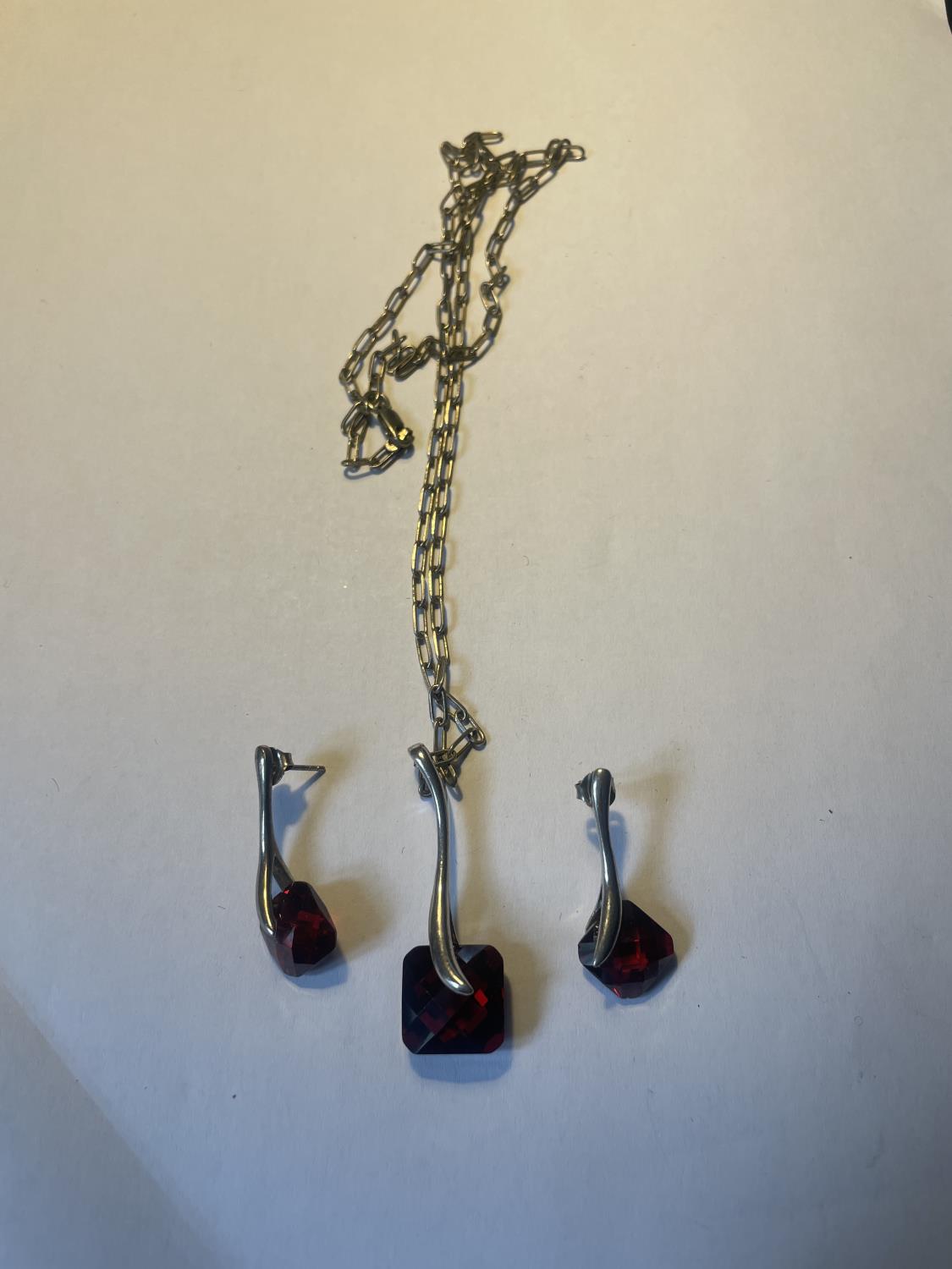 A SILVER AND RED STONE NECKLACE AND EARRING SET