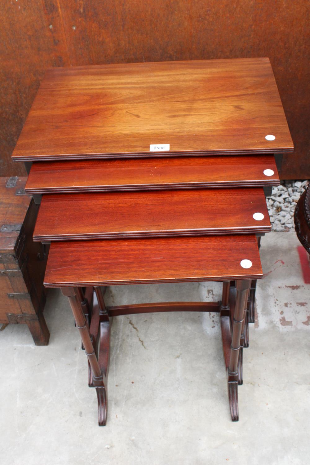 A MAHOGANY 19TH CENTURY STYLE NEST OF FOUR TABLES