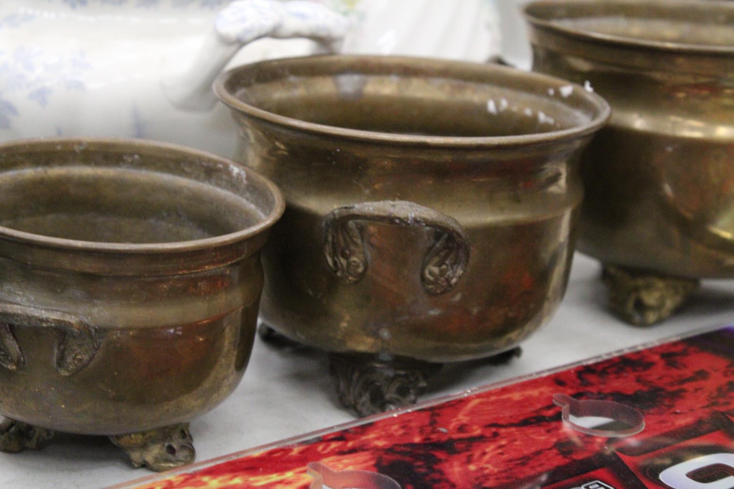 THREE GRADUATED BRASS FOOTED AND HANDLED POTS - Image 4 of 5