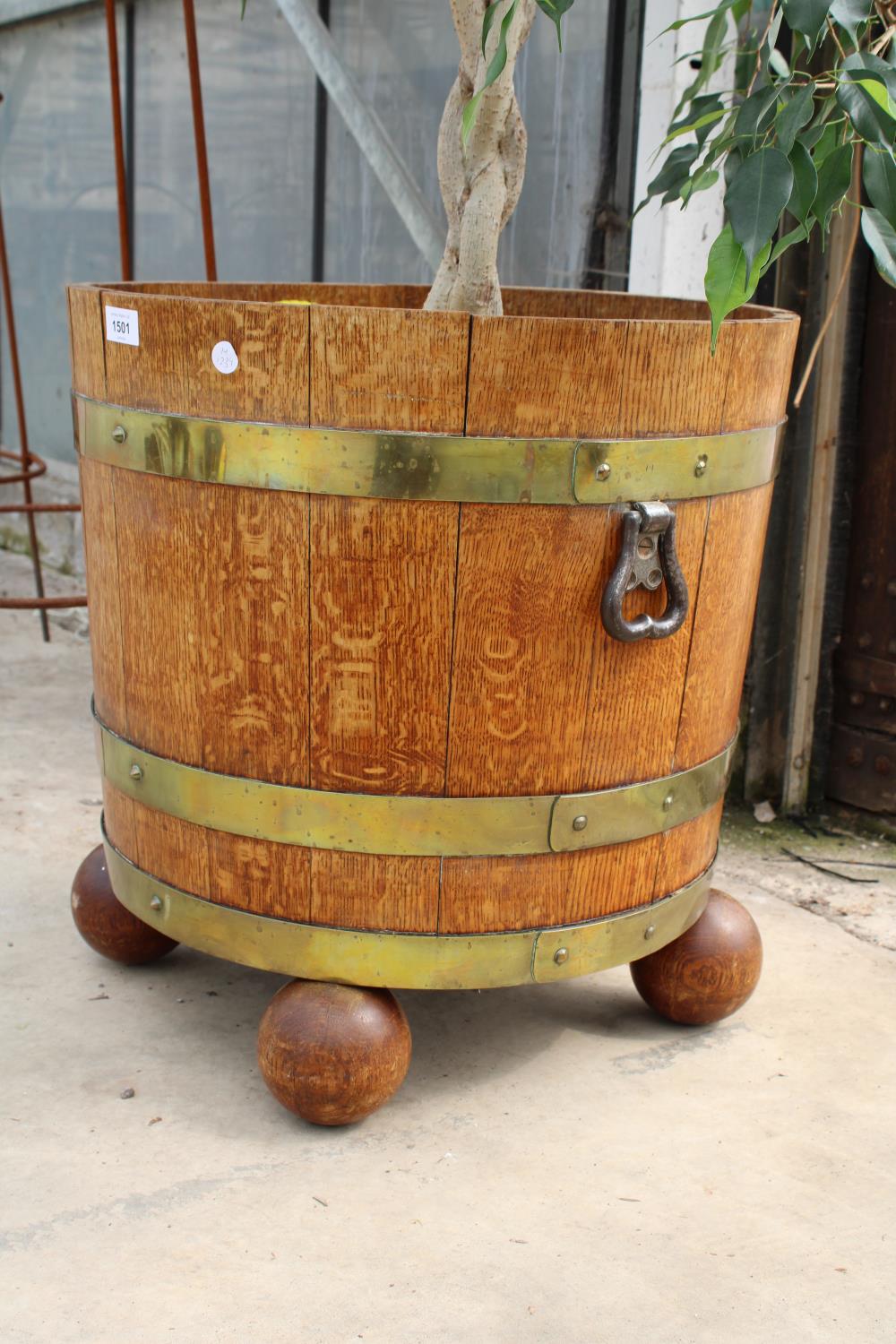 A VINTAGE OAK AND BRASS BANDED TWIN HANDLE BARREL PLANTER ON A BALL FEET BASE AND COMPLETE WITH AN - Image 3 of 5