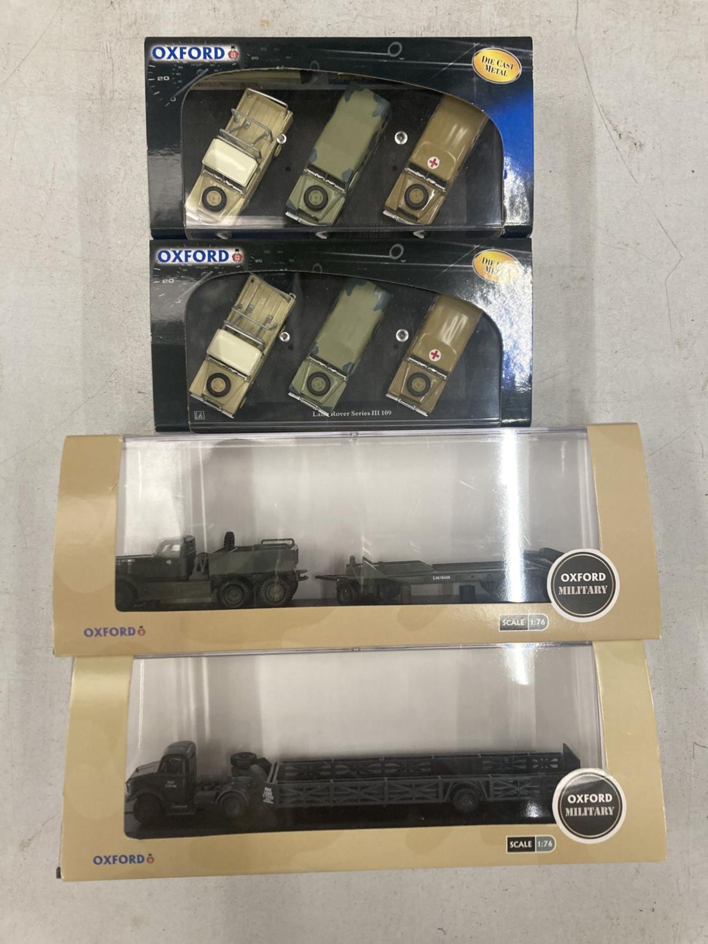 FOUR BOXED OXFORD MILITARY SERIES VEHICLES TO INCLUDE TWO WITH THREE LAND ROVERS IN EACH