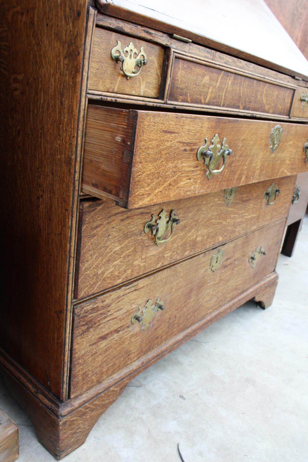 A GEORGE III OAK BUREAU WITH FITTED INTERIOR, TWO SHORT AND THREE LONG GRADUATED DRAWERS TO THE BASE - Image 4 of 4