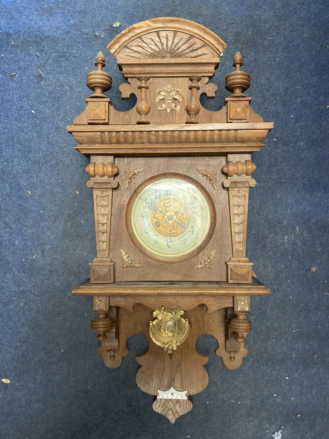 A VINTAGE OAK CASED WALL CLOCK, WITH CARVED DETAIL AND PENDULUM