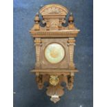 A VINTAGE OAK CASED WALL CLOCK, WITH CARVED DETAIL AND PENDULUM