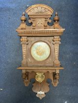 A VINTAGE OAK CASED WALL CLOCK, WITH CARVED DETAIL AND PENDULUM