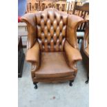 A BROWN CHESTERFIELD STYLE WINGED FIRESIDE CHAIR ON FRONT CABRIOLE LEGS